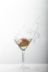 Splash from orange in a glass of cocktail, On the white background