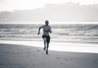 Professional athlete runner man running using heart rate monitor and smart watch training on beach