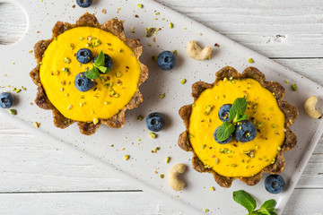 Vegan food dessert. raw vegan yellow mango cakes with fresh blueberries and mint. healthy delicious...