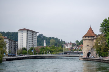 Obraz premium Beautiful view of stone medieval tower beside the river with cloudy sky background , copy space
