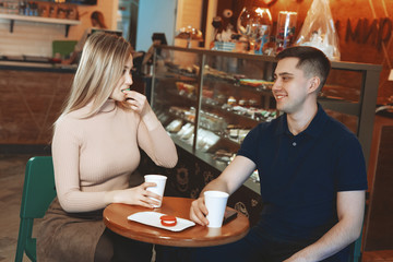 Two casual students having a cup of coffee in college canteen