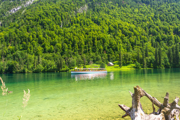 Konigssee lake with clear green water, reflection, mountain and ferry ship, Bavaria, Germany