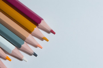 multicolored pencils on a white background. top view.