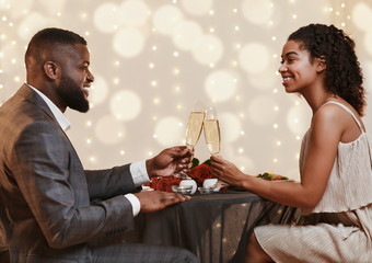 Young black couple drinking champagne for their love