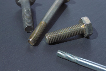 old bolts and nuts on a dark background.