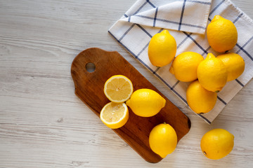Ripe Yellow Organic Lemons on a white wooden surface, overhead view. Flat lay, top view, from above. Space for text.