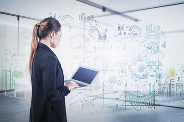 Woman with laptop and business plan in office