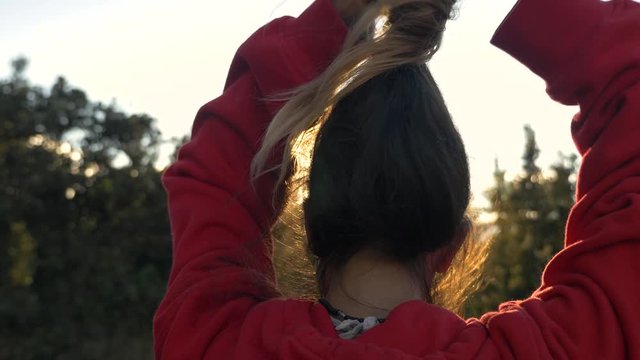 headshot from behind of girl letting hair down in hawaii at sunset