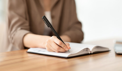 Cropped image of manager taking notes with pen