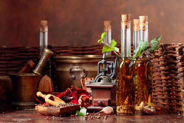Bottles of olive oil with various spices and vintage cooking utensils.