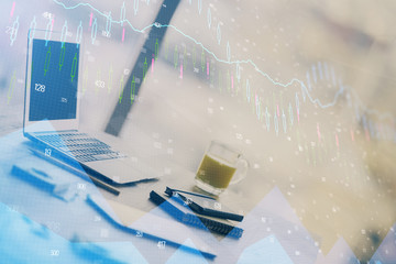 Stock market graph on background with desk and personal computer. Double exposure. Concept of financial analysis.