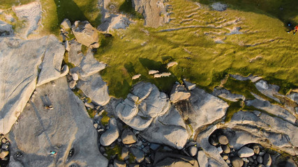 Close-up top view of an unusual stone landscape partially covered with grass