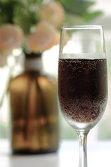 glass goblet with red drink display on table in sun shine