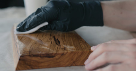 woodworker applying oil finish to olive wood board