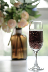 glass goblet with red drink display on table in sun shine