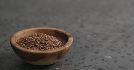 flaxseed in olive bowl on terrazzo countertop with copy space