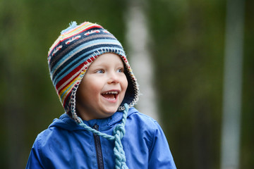 Happy cheerful smiling boy with blue eyes, wearing hat
