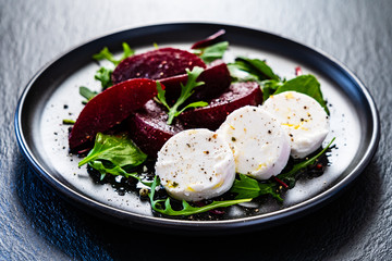  Beetroot salad with goat cheese on black stone plate