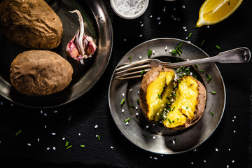 Jacket potatoes on black stone board