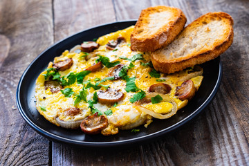 Breakfast - omelette with champignon on wooden background