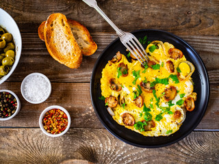 Breakfast - omelette with champignon on wooden background