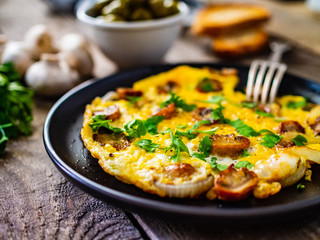 Breakfast - omelette with champignon on wooden background