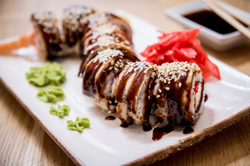 Sushi roll Green Dragon with avocado, ell, wasabi and ginger. Restaurant.