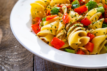 Pasta with vegetables on wooden background