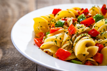Pasta with vegetables on wooden background
