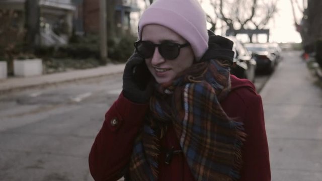 Canada - Woman Talking On Her Phone While Walking Along The Roadside On A Cold Winter Day - Closeup Shot