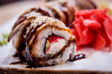 Sushi roll Green Dragon with avocado, ell, wasabi and ginger. Restaurant.