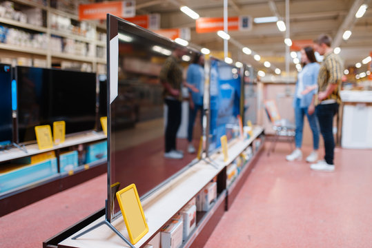 Couple at the shelf with TV in electronics store