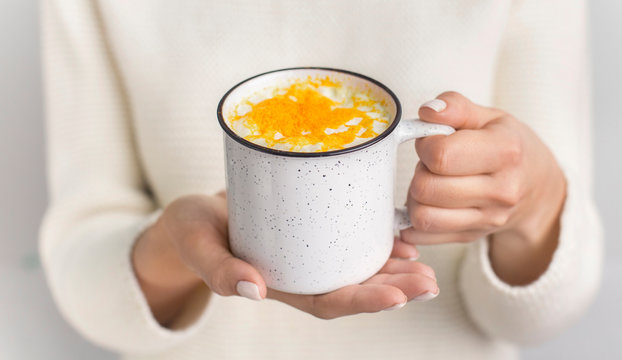 Unrecognizable woman holding golden milk made with turmeric