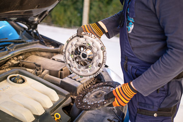 Car mechanic is changing clutch.