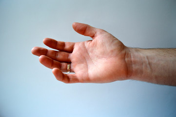 Male's hand with gold ring isolated on white