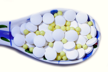 Coronavirus treatment concept glass  spoon with white and yellow pills