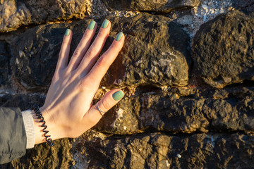 Female hand with manicure on a background of stones