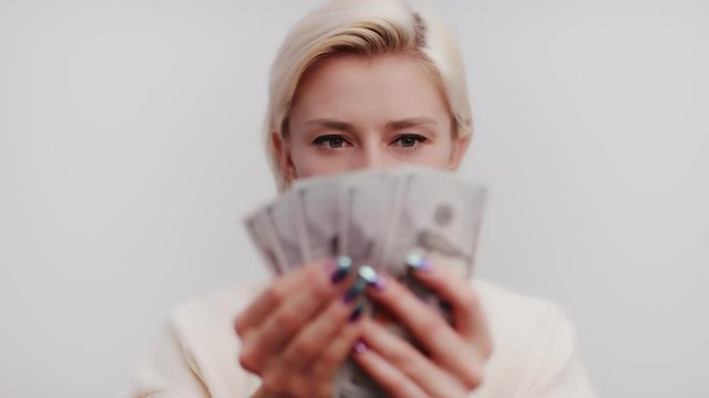 Materialistic woman counting dollar note bills and getting happy