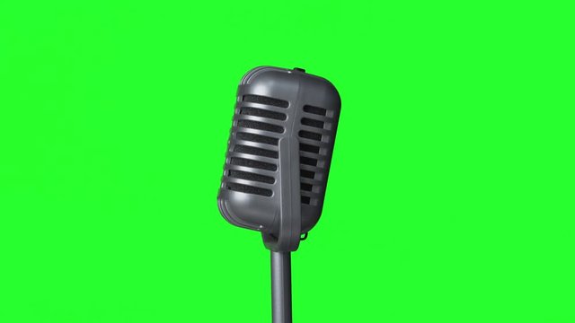 Isolated metal microphone on a turn table with a keyable green screen background