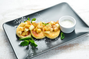 Cheese pancakes with sour cream. Dessert. Top view. Free space for your text.