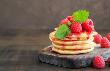 pancakes with raspberry on a dark background.