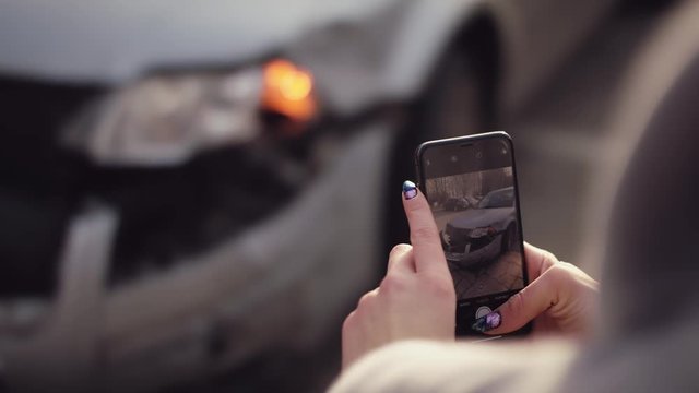Woman Taking Pictures with her Cell Phone of Her Car in an Accident