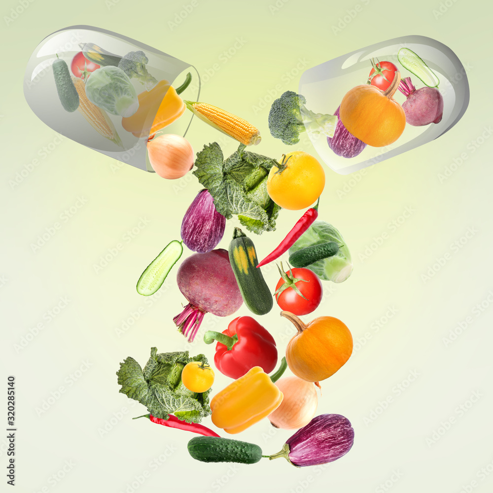 Wall mural capsule with falling vegetables on green background