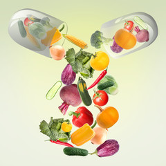 Capsule with falling vegetables on green background