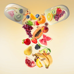 Capsule with falling fruits and nuts on color background