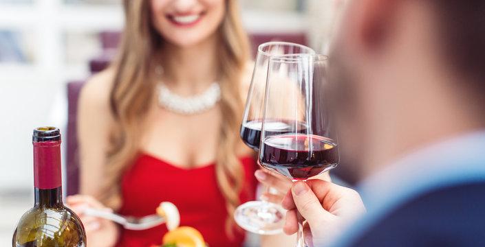 Couple toasting with red wine in romantic restaurant
