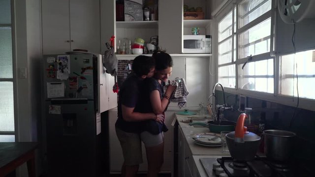 Boyfriend Surprises Girlfriend with a Hug in the Kitchen, Profile Shot