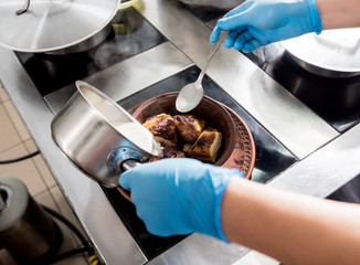 Roasted chicken with potato and vegetables on kitchen stove. 