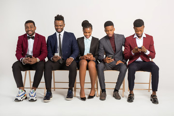 beautiful african people in suits on a white background with phones in their hands