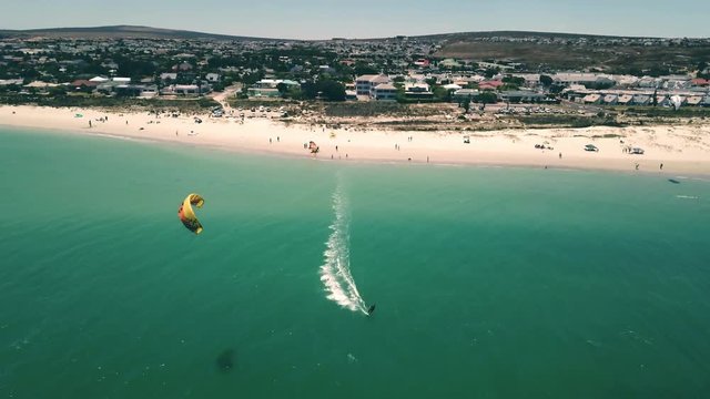 epic aerial Drone shot of Langebaan Beach, Cape Town, South Africa with paradise turquise ocean, beautiful beach and water sport kite sufing in frame. Pefrect summer vacation and holiday.